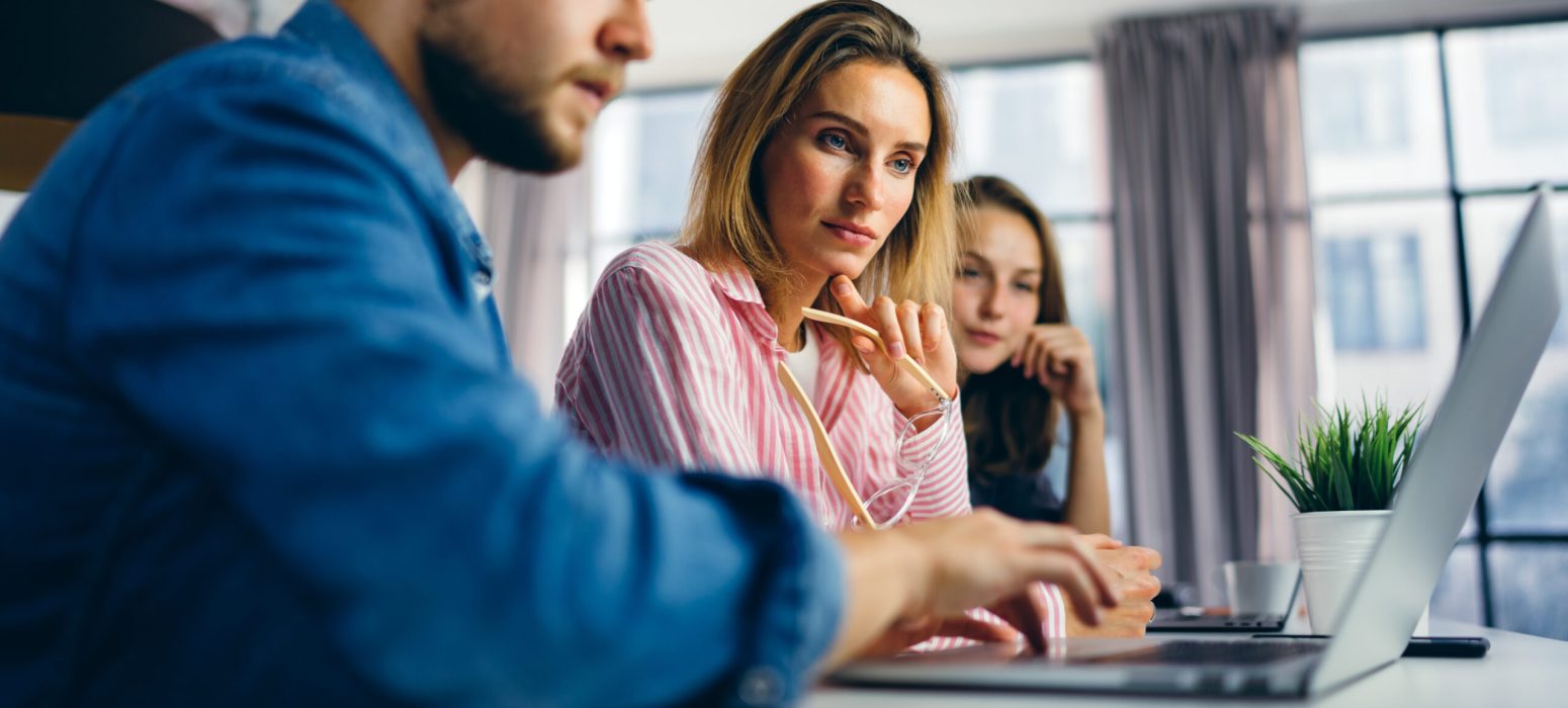 Group of young people working together. Creative business people in modern office. Hipster team in coworking. Young modern colleagues. Teamwork. Startup concept