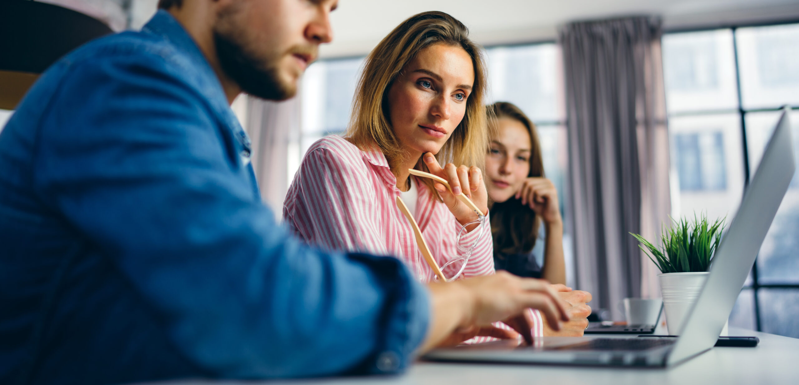 Group of young people working together. Creative business people in modern office. Hipster team in coworking. Young modern colleagues. Teamwork. Startup concept